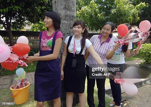 Teenagers distribute balloons and flowers as people celebrate Valentine's day on February 14, 2008. Indonesians along with the rest of the world...