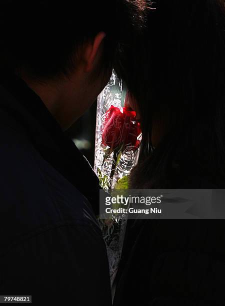 Chinese young lovers hold a rose on Valentine's Day February 14, 2008 in Beijing, China. Valentine's Day has become one of the most popular Western...