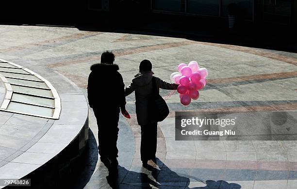 Chinese young lovers take a stroll on Valentine's Day February 14, 2008 in Beijing, China. Valentine's Day has become one of the most popular Western...