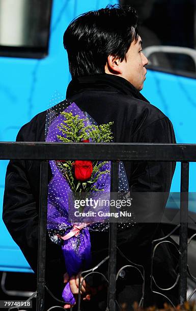 Chinese young man with flower waits for his girlfriend on Valentine's Day February 14, 2008 in Beijing, China. Valentine's Day has become one of the...