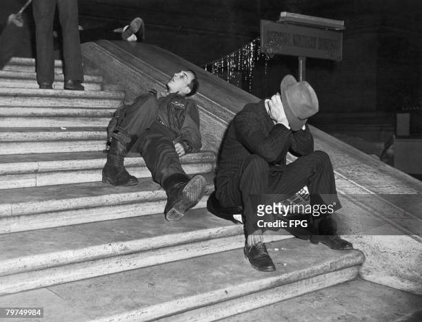 Revellers recovering from New Years Eve celebrations on the steps of Grand Central Station, New York, circa 1940.