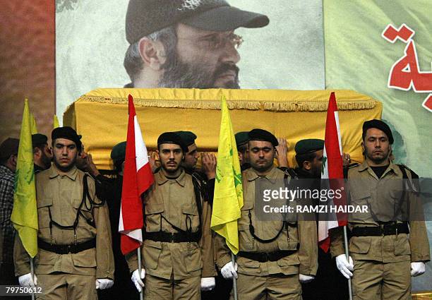 Hezbollah militants carrying the coffin of slain Hezbollah leader Imad Mughnieh , walk past a honor guard, during his funeral in Beirut's southern...