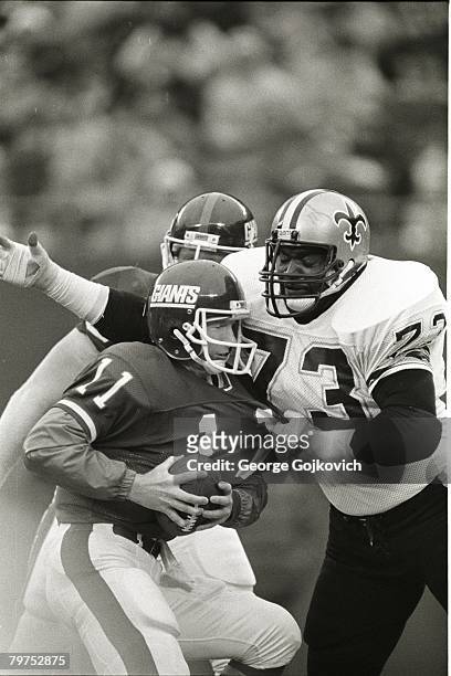 Defensive lineman Frank Warren of the New Orleans Saints sacks quarterback Phil Simms of the New York Giants during a game at Giants Stadium on...