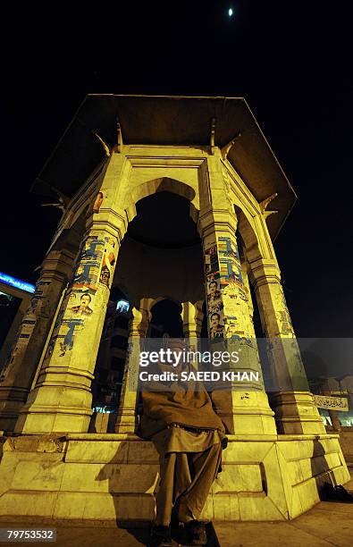 Man spends his evening time at a monument decorated with the posters of the different canditates contesting the upcoming general elections in the...