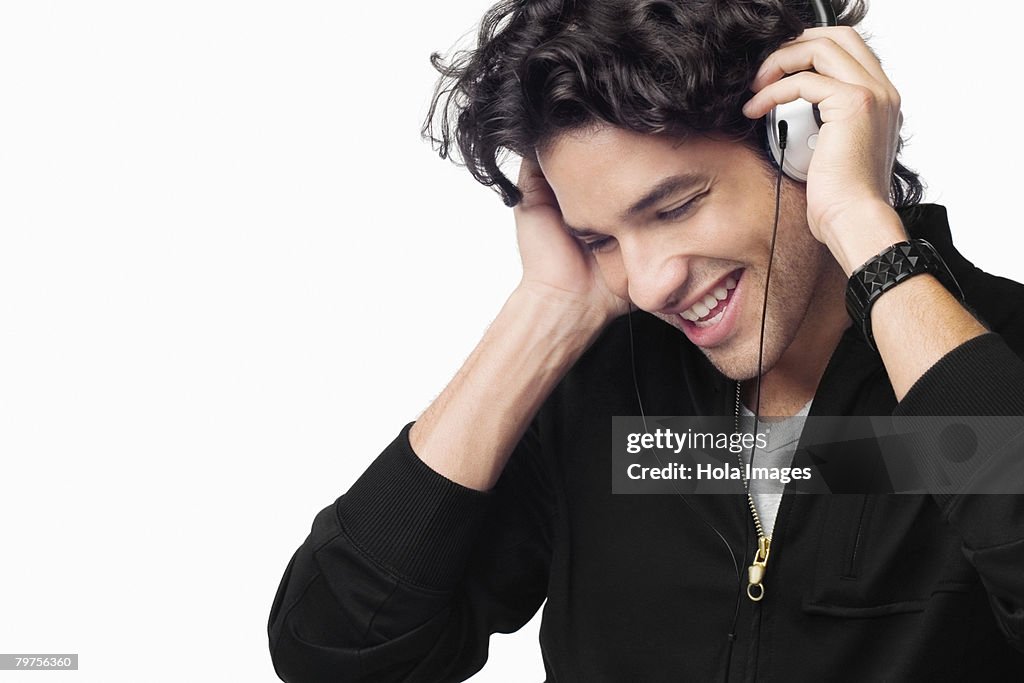 Close-up of a young man listening to music and smiling