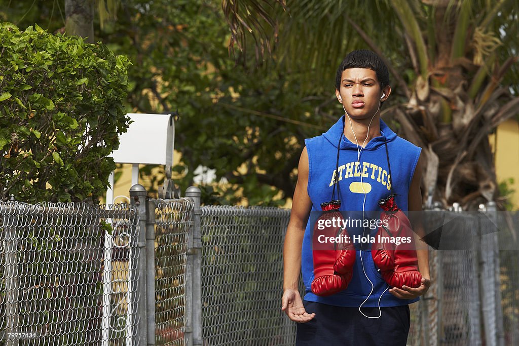 Teenage boy listening an mp3 player and walking