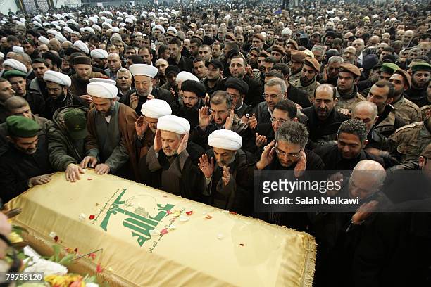 Hezbollah members pray at the coffin of assassinated commander Imad Moughniyeh during his funeral on February 14, 2008 in a suburb of Beirut,...