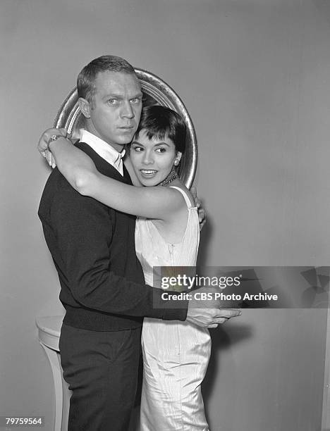 Married American actors Steve McQueen and Neile Adams embrace during the filming of an episode of the television anthology series 'Alfred Hitchcock...