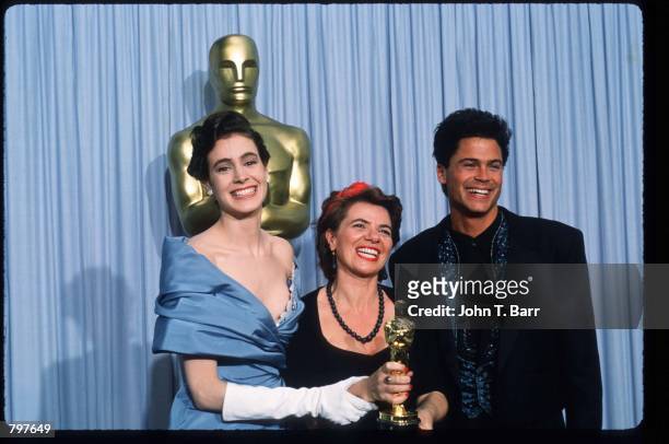 Editor Gabriella Cristiani holds her Best Film Editing Oscar for "The Last Emperor" while standing next to actor Rob Lowe and actress Sean Young at...
