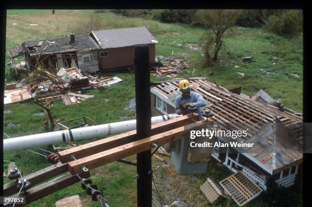 Relief worker repairs a telephone line September 27, 1989 in South Carolina. Hugo is ranked as the eleventh most intense hurricane to strike the US...