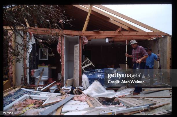 Men carry fishing poles through the remains of a home September 27, 1989 in South Carolina. Hugo is ranked as the eleventh most intense hurricane to...