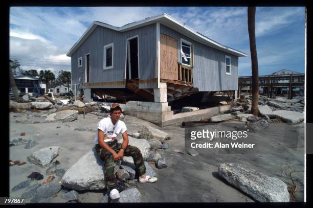 Man sits in front of a damaged building September 27, 1989 in South Carolina. Hugo is ranked as the eleventh most intense hurricane to strike the US...