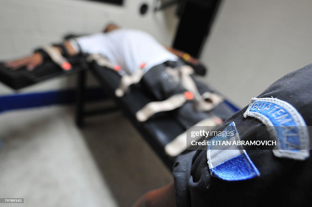 An inmate lays on a stretcher as he take