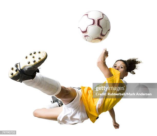 teenage girl kicking soccer ball - sich zu boden werfen stock-fotos und bilder
