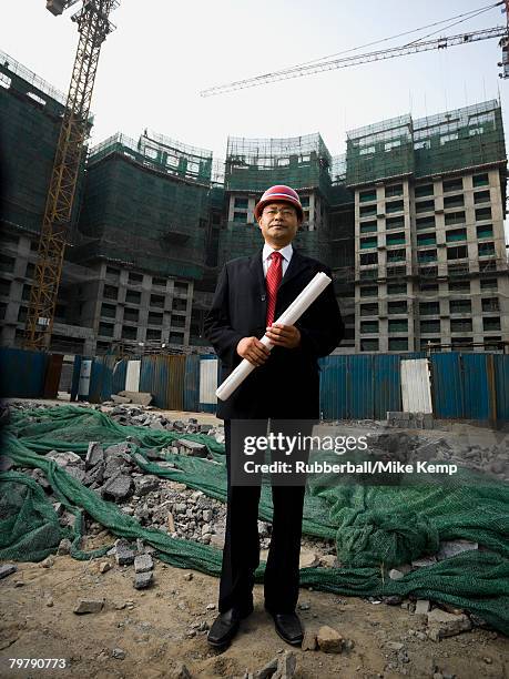 construction site foreman with blueprints outdoors - business man overseeing blueprints outdoor stock-fotos und bilder