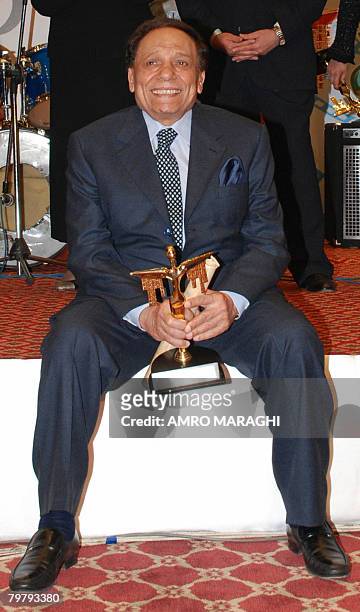 Egyptian comedian Adel Imam smiles as he holds the best actor award for his role in the film 'Morgan Ahmed Morgan' during the 29th Egyptian cinema...