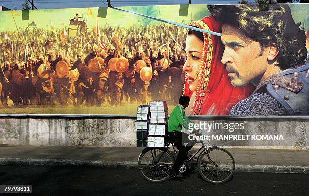 An Indian cyclist rides past a hoarding for the Bollywood film Jodhaa Akbar in New Delhi on February 16, 2008. A lavish film about the love between a...