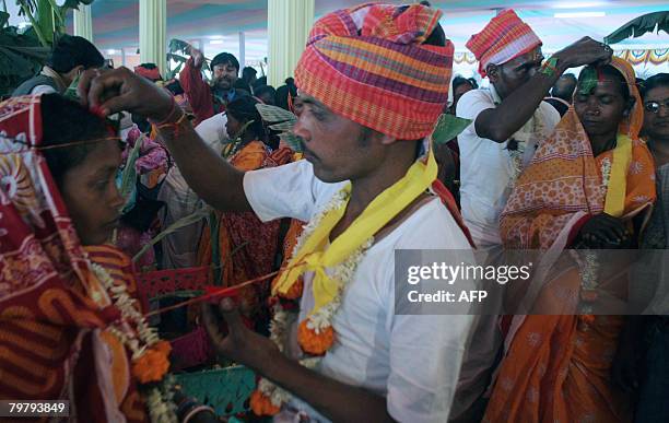 Indian tribal brides are anointed by their grooms as they take part in a mass marriage ceremony during a religious conference in Siliguri on February...