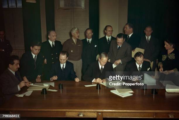 View of the Representatives of the Four Powers seated at a desk to sign the Nuremberg Charter, the agreement that sets down the rules and procedures...