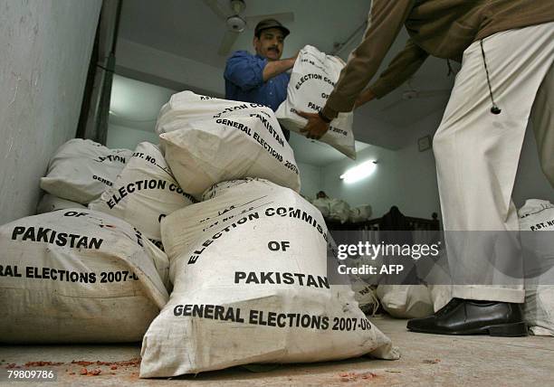 Pakistani workers deliver the bags of election material at a distribution station in Lahore on February 17 a day before the country's general...