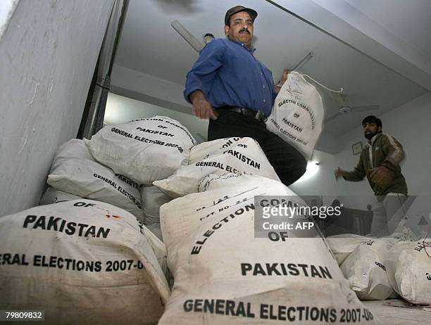 Pakistani workers deliver the bags of election material at a distribution station in Lahore on February 17 a day before the country's general...