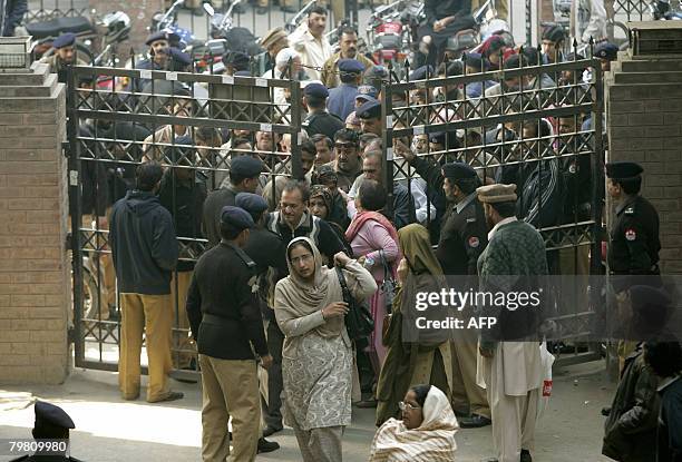 Pakistani people enter a distribution station to receive election material in Lahore on February 17 a day before the country's general elections....