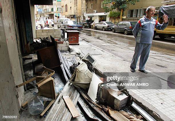 Lebanese shop owner Abu Rabih, stands outside his burnt out computer store destroyed during last night's street clashes in Beirut's Basta district on...