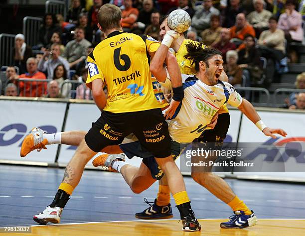 Grzegorz Tkaczyk and Sergiy Shelmenko of the Rhein-Neckar Loewen compete with Bertand Gille of Hamburg during the Handball Bundesliga match between...