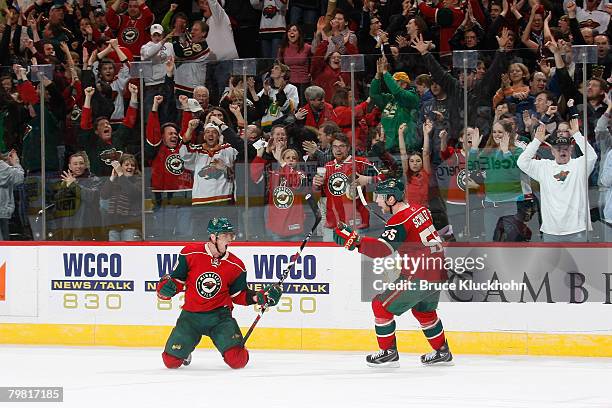 Marian Gaborik is congratulated by Nick Schultz of the Minnesota Wild after scoring the game winning goal against the Nashville Predators during the...