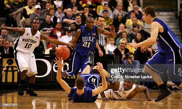 Jon Scheyer of the Duke Blue Devils collides with Jamie Skeen of the Wake Forest Demon Deacons during their game at Lawrence Joel Coliseum on...