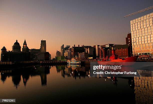 Liverpool's Albert Dock sits against the backdrop of the setting sun and The Liver Building on February 17 Liverpool, England. The historic dock yard...