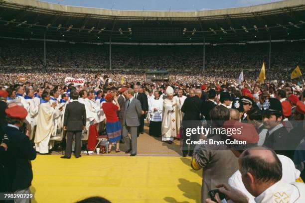 Pope John Paul II walks through the crowds to conduct his first open-air mass at Wembley Stadium on the second day of the Pope's six-day tour of...