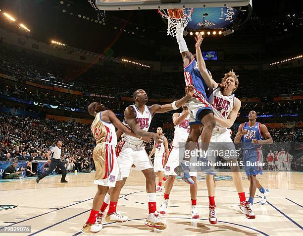 LeBron James of the Eastern Conference dunks over Dirk Nowitzki and Amare Stoudemire of the Western Conference during the fourth quarter of the 2008...