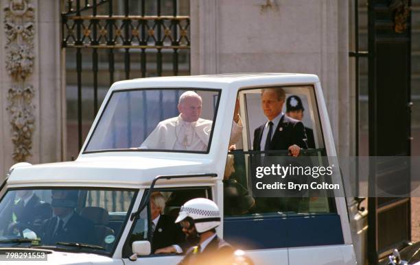 Pope John Paul II waves from the popemobile as he leaves Buckingham Palace following his audience with Queen Elizabeth II, on the first day of his...