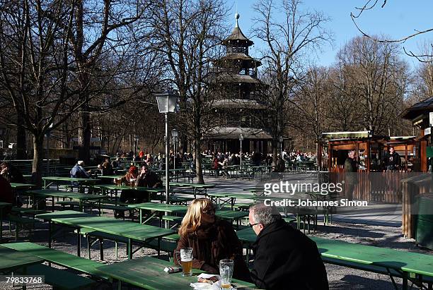 People enjoys sitting in the beer garden in front of Chinesischer Turm in the English Garden on February 19, 2008 in Munich, Germany. Germany...