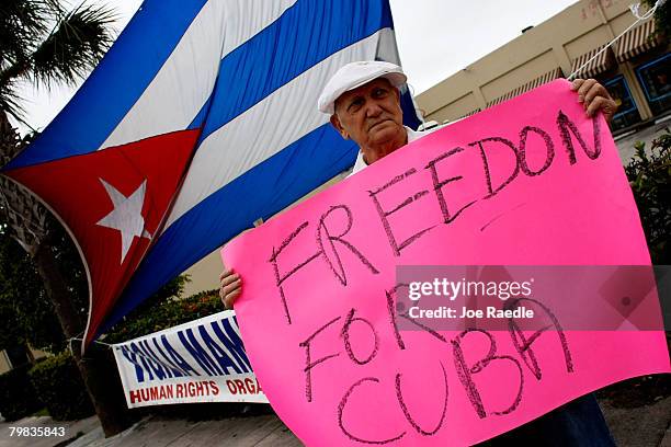 Miguel Gomez Beruvides holds a sign as he reacts to the news that Cuban President Fidel Castro announced he will not accept a new term in office in...