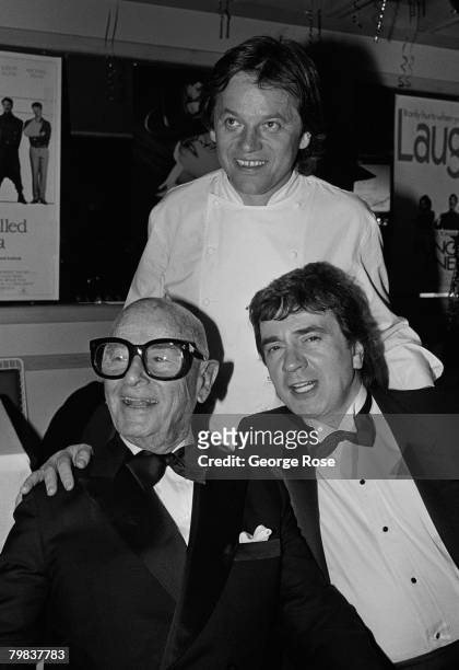 Restraunt owner Wolfgang Puck poses with Irving "Swifty" Lazar and Dudley Moore at the 1989 West Hollywood, California, Oscar Party held at Puck's...