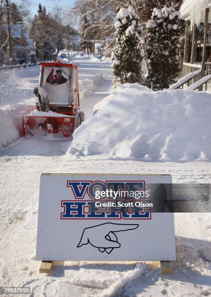 Nick Knuth, who works for the village, clears snow near the polling place February 19, 2008 in Hortonville, Wisconsin. Despite frigid temperature and...