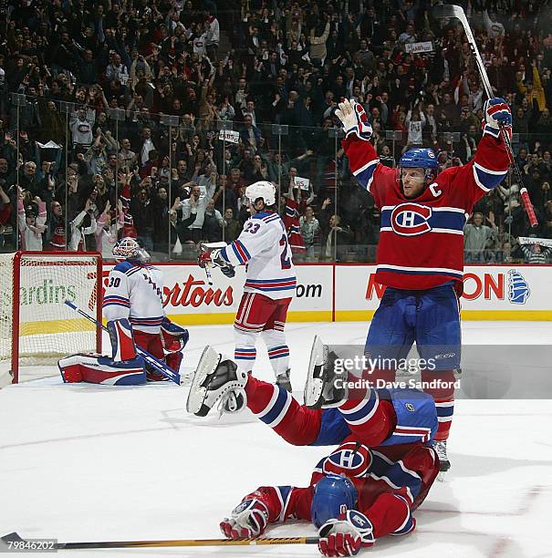 Alex Kovalev of the Montreal Canadiens lies on the ice as he celebrates his game tying goal with teammate Saku Koivu while Henrik Lundqvist of the...