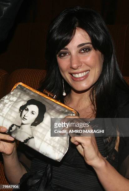 Lebanese film director and actress Nadine Labaki holds a purse with a picture of Egyptian mid-1900s film diva Faten Hamama, an ex-wife of...