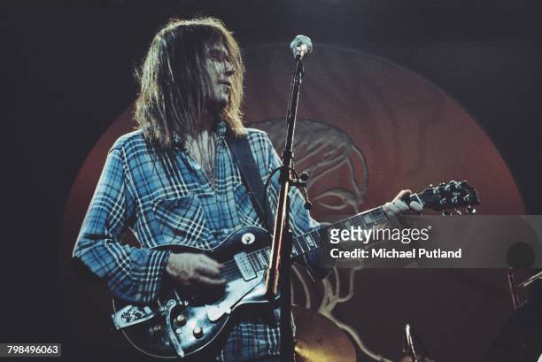 Canadian singer-songwriter Neil Young performs on stage with Crazy Horse at Hammersmith Odeon, London, 28th March 1976.