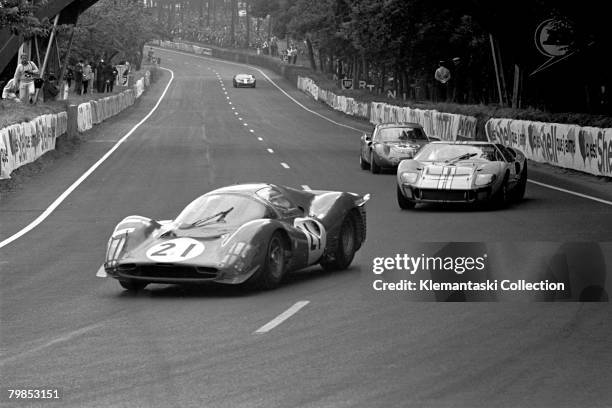 The Ferrari 330P3 of Lorenzo Bandini and Jean Guichet leading the Ford GT40 Mk. II of Denis Hiulme and Ken Miles through Tertre Rouge during The 24...