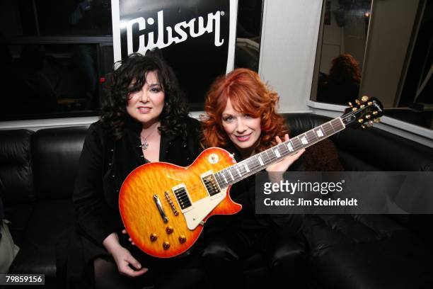 Rock band Heart pose for a portrait in the Gibson tour bus holding an Epiphone Les Paul guitar. Anaheim California at the NAMM show outside the...