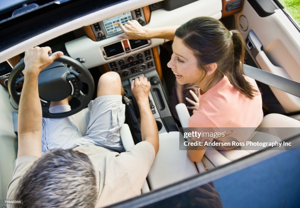 Hispanic couple driving in car