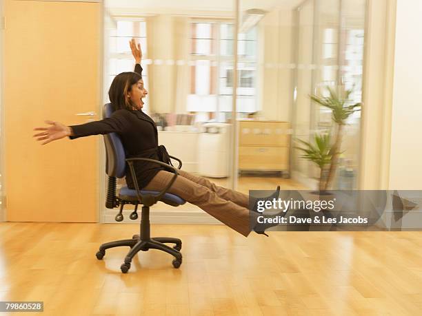 indian businesswoman rolling in office chair - office chair stock pictures, royalty-free photos & images