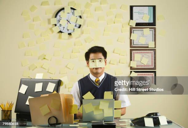 asian businessman with sticky notes all over wall and face - clock person desk stockfoto's en -beelden