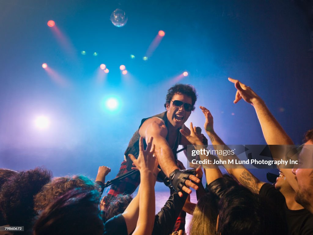 Male rock star on stage interacting with audience