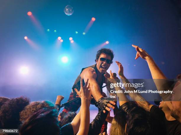 male rock star on stage interacting with audience - popular music concert imagens e fotografias de stock