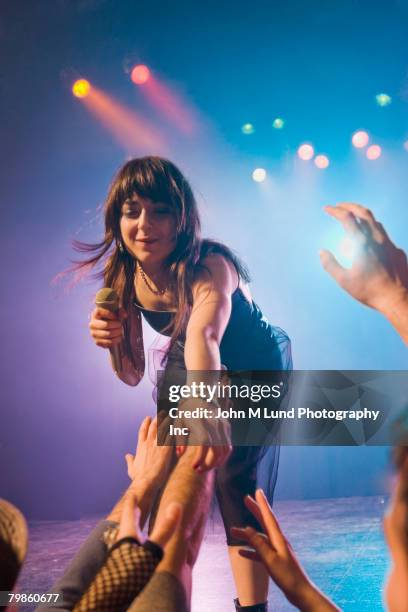 female rock star on stage interacting with audience - inarcare la schiena foto e immagini stock