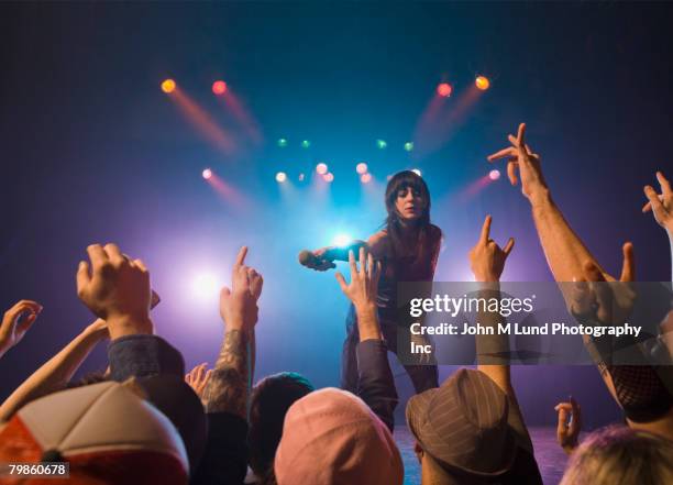 female rock star on stage interacting with audience - concierto rock fotografías e imágenes de stock